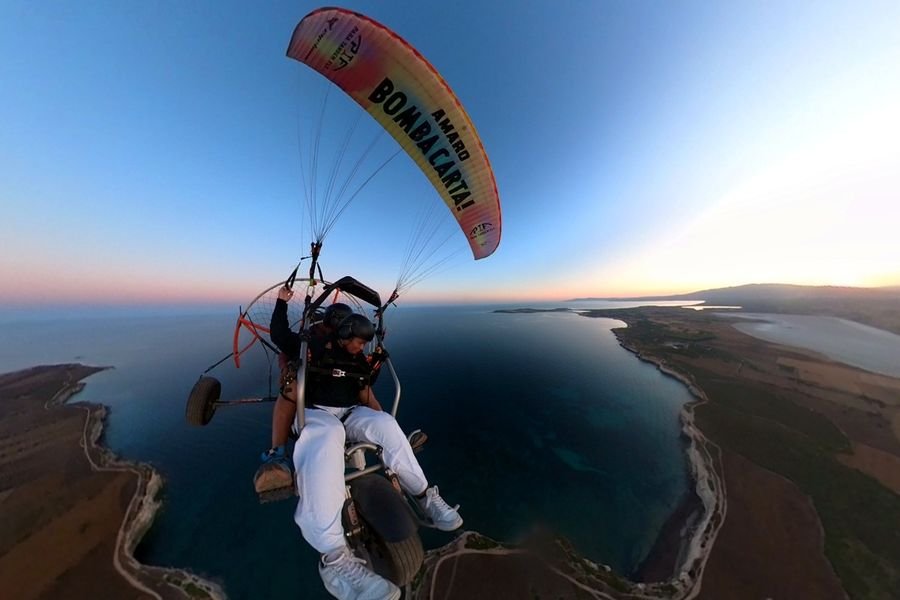 Volo panoramico in paramotore all’alba sopra la costa del Sinis in Sardegna
