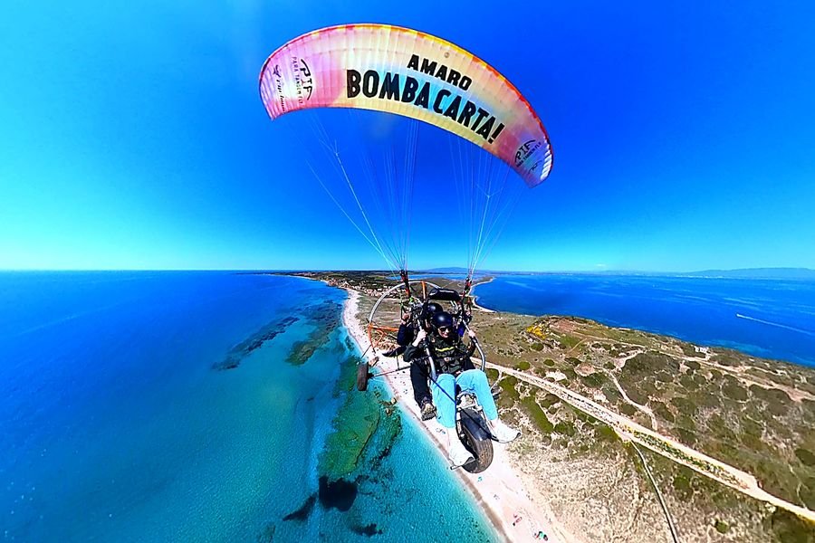 Volo in paramotore tandem sopra il mare cristallino della penisola del Sinis in Sardegna